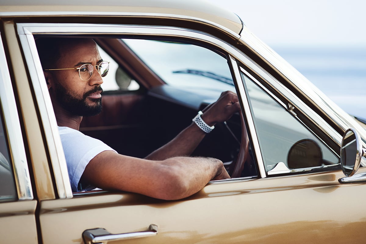 Man with glasses driving a car