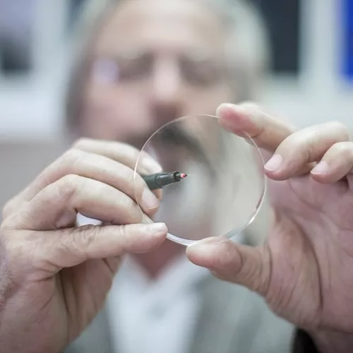 Image of optician holding a lens