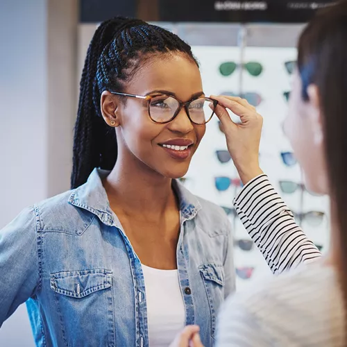 Opticien ajustant des lunettes sur le visage de son patient